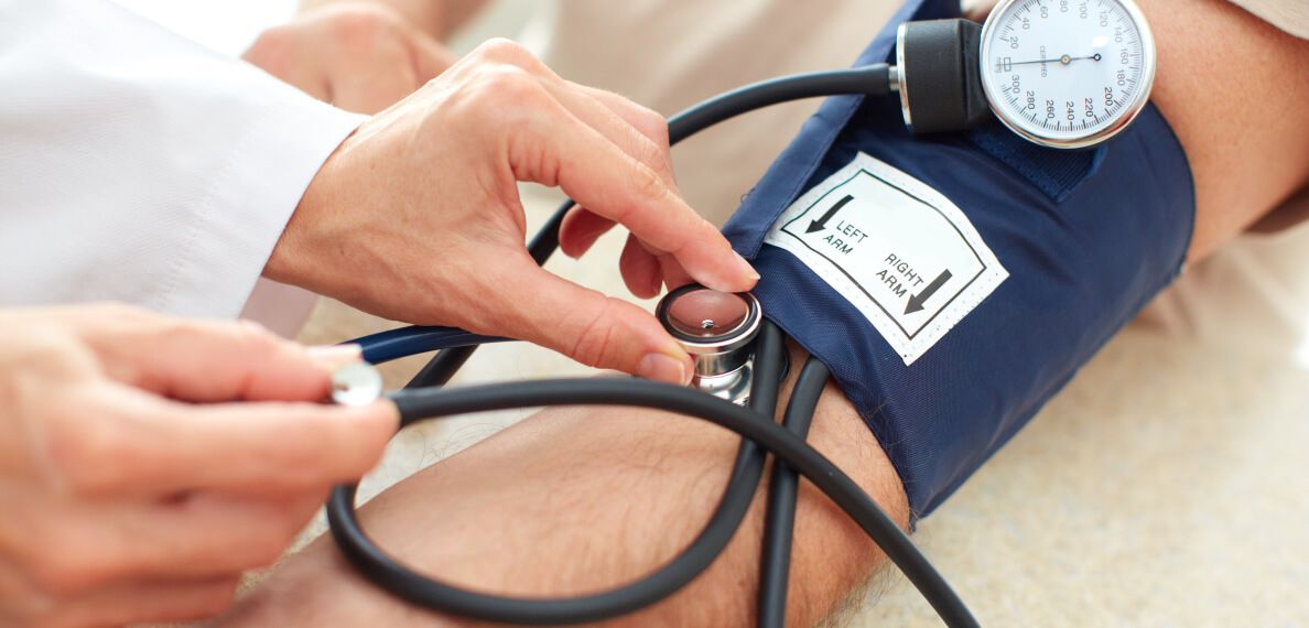Ein Arzt misst den Blutdruck eines Patienten mit einem Stethoskop